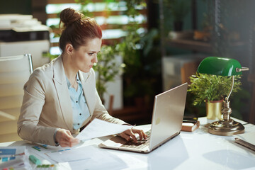 bookkeeper woman in light business suit in green office
