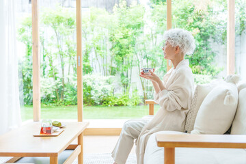 リビングでお茶を飲むシニア女性