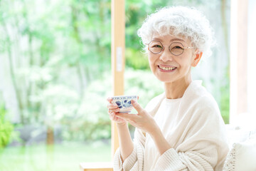 リビングでお茶を飲むシニア女性のポートレート