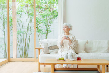 リビングでお茶を飲むシニア女性