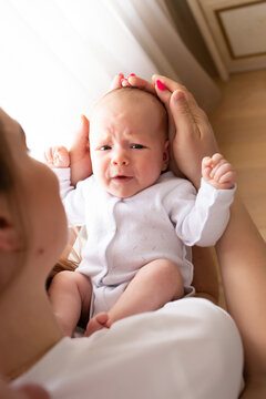 young parents hold the baby in their arms. family lifestyle photo with baby. family concept. baby crying in parent's arms