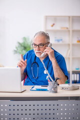 Old male doctor in telemedicine concept