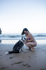 girl and her dog playing on the beach