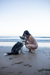 girl and her dog playing on the beach