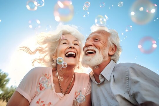 happy senior couple together smiling with soap bubbles at outdoor