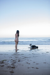 girl and her dog playing on the beach