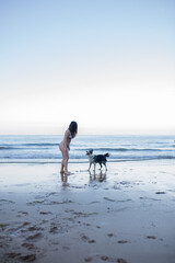 girl and her dog playing on the beach