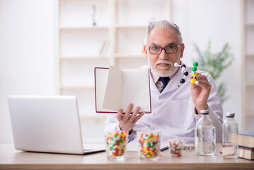Old male doctor holding molecular model