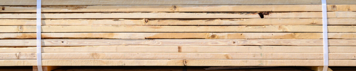 Naklejka premium Side view of a stack of lumber, materials for building a new house 