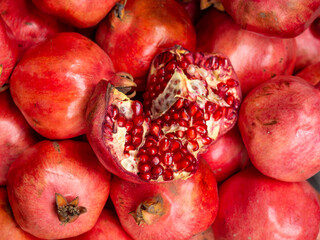Fresh pomegranate harvest. Background of winter fruits. Red fruits. Opened pomegranate fruit. Pulp.