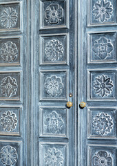 Sun Faded Black Double Doors with Golden Fixtures.
