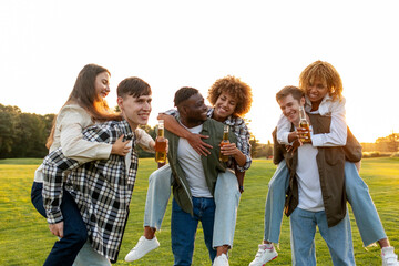 three couples of young multiracial people drinking beer and celebrating toast at party in the park