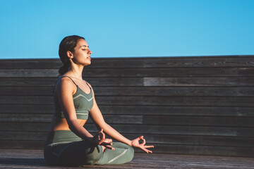 Calm female meditating peacefully in lotus asana