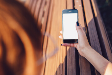 Faceless woman using smartphone in street