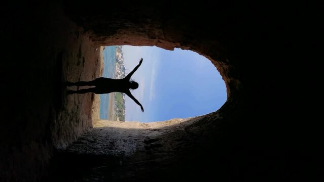 Vertical video of girl opening her arms in Anzio cave
