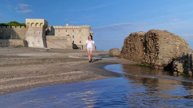 Girl on the beach in front of the Odescalchi castle in Ladispoli