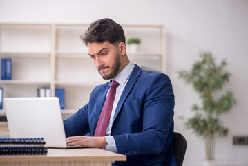 Fototapeta premium Young male employee working in the office