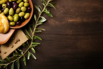 Tuinposter Overhead view of olives bread and olive oil on wooden background © The Big L