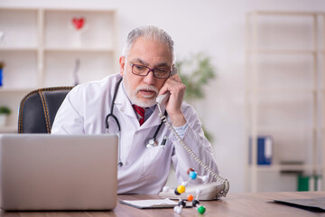 Fototapeta premium Old male doctor in telemedicine concept