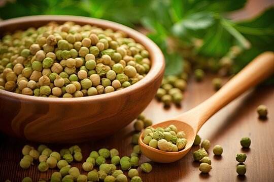 Uncooked dried chickpeas and raw green chickpea pod on wooden table with legume background