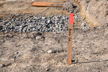 Building corner survey marker, base dug out of leveled dirt and ready for foundation installation...