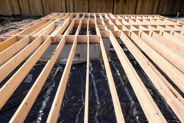 Beginnings of a new home, wood floor joists installed over concrete foundation
 - obrazy, fototapety, plakaty