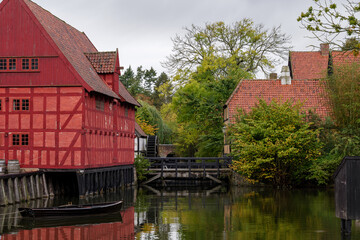 Fototapeta na wymiar Outdoor overcast scenery of canal surrounded with old traditional wooden houses at Den Gamle By in Aarhus, Denmark. 
