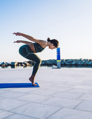 Sporty woman balancing while training yoga