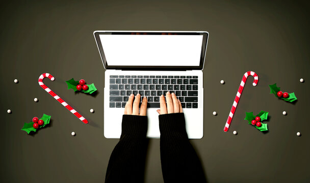 Person using a laptop computer with Christmas decorations from above