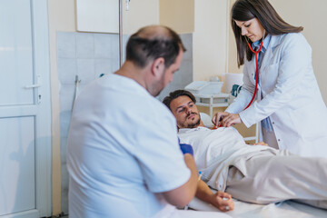 Obraz premium Experienced Doctor Providing Medical Infusion Therapy in Hospital Room