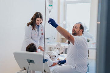 A man undergoing infusion therapy in a hospital room, received by a specialist for a medical illness.
