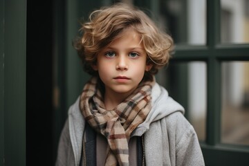 Portrait of a cute little boy in a gray coat and scarf