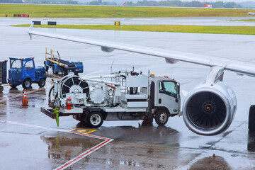 Passenger plane is being serviced by ground services before it is ready to take off again in passenger terminal