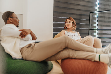 A diverse group of business employees taking a break from work in a modern office, lying on lazy...