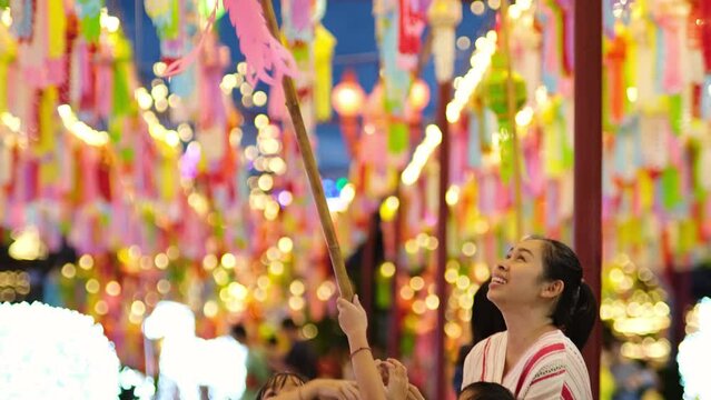 Asian families make wishes and hang lanterns during The Hundred Thousand Lantern Festival or Yi Peng Festival in northern Thailand.
