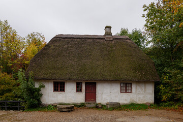Fototapeta na wymiar Outdoor exterior view of old traditional wooden barn house cottage with thatched roof at Den Gamle By.