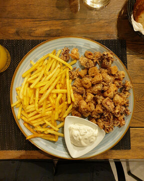 Croatian food, calamari rings served with hot potato french fries