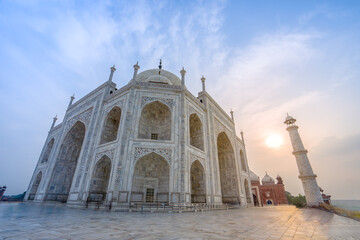 Side view of the Taj Mahal's white domes and white towers at sunset. The Taj Mahal is a treasure of Indian Muslim art. UNESCO World Heritage Site.