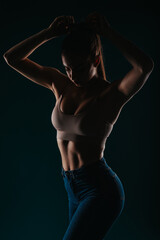 Confident Female in Dark Background: Fit Girl Posing with Six Pack and Muscular Torso, Impressive Body Transformation
