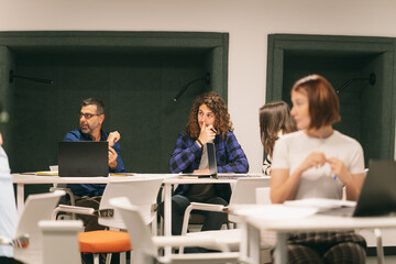Coworkers listening and looking at someone while working on a project