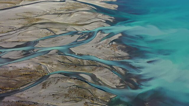 Stunning aerial drone view of the turquoise water of Lake Pukaki meeting the Tasman River delta on New Zealand's South Island.