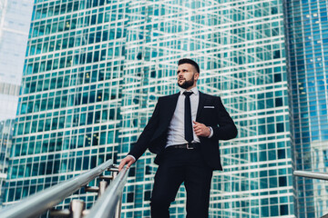 Fototapeta premium Businessman walking down stairs away from modern office building