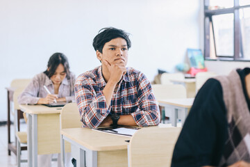 University student listening lecture while attending a class in the classroom.