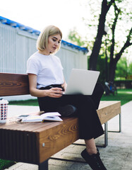 Pretty female freelancer working in park