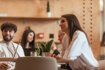 Young and beautiful businesswoman sitting at the cafe and listening to the man talk