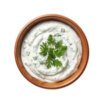 Top view of tzatziki dip in a wooden bowl isolated on a white background