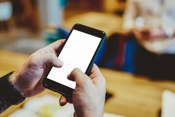 Faceless man texting on smartphone in office