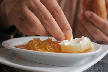 butter cream and honey in a bowl on table .