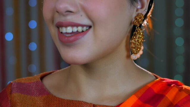 A closeup shot of a beautiful Indian girl swinging her traditional earrings - festive mood  diwali vibe. Pretty Indian woman getting ready for Diwali festival - festival of lights
