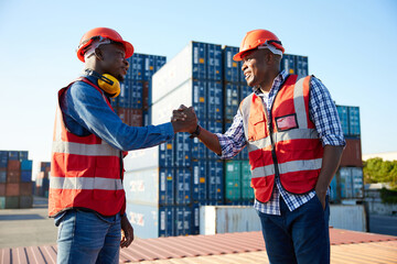 African factory workers or engineer shaking hands together in containers warehouse storage